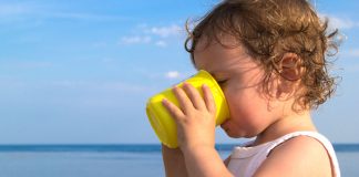 Dehydration in Children A child drinking water from a yellow mug