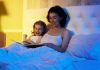 Storytelling for Children A mother and daughter reading a book together in bed