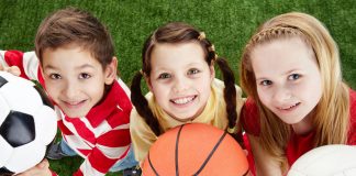 List of Best Sports for Kids to Play Three kids holding balls on the grass