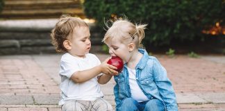 How to Teach a Child to Share A little boy sharing an apple with a little girl