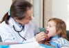 Tonsillitis in Children A doctor checking a little girl's throat