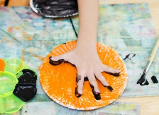 15 Creative Paper Plate Craft Ideas For Kids A child painting on a paper plate