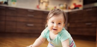 Your 27 Week Old Baby – Development, Milestones & Care A baby crawling on a wooden floor