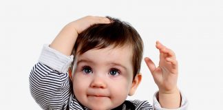 Head Banging in Babies and Toddlers A baby holding its head
